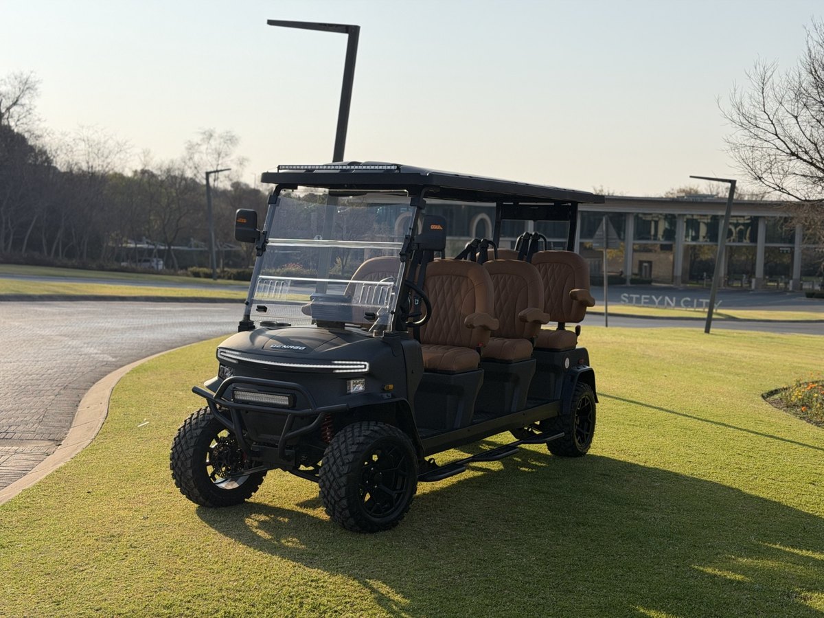 Black Denago cart with tan seats beside a golf course