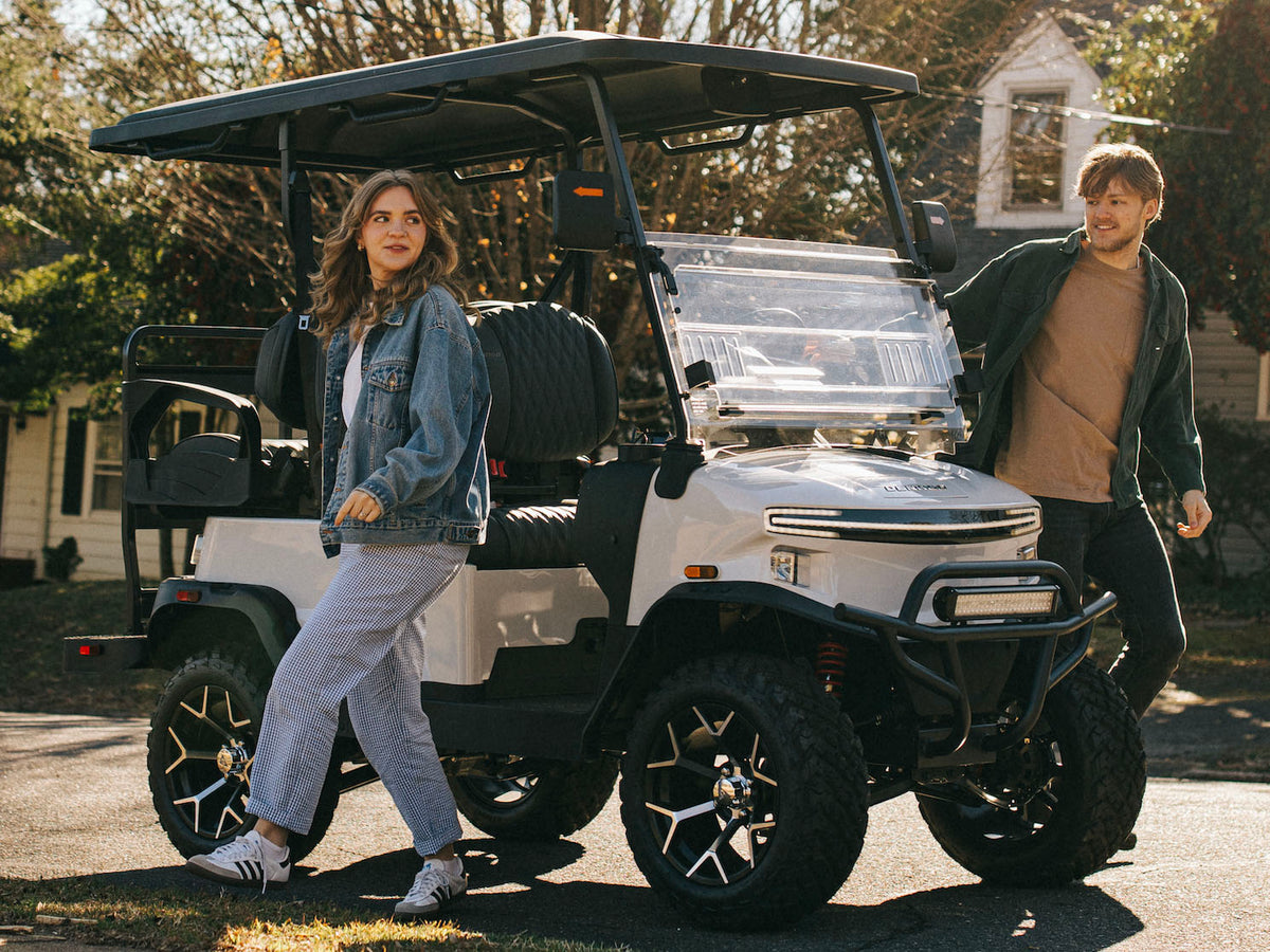 Couple standing beside a white Denago Nomad XL in a neighbourhood setting