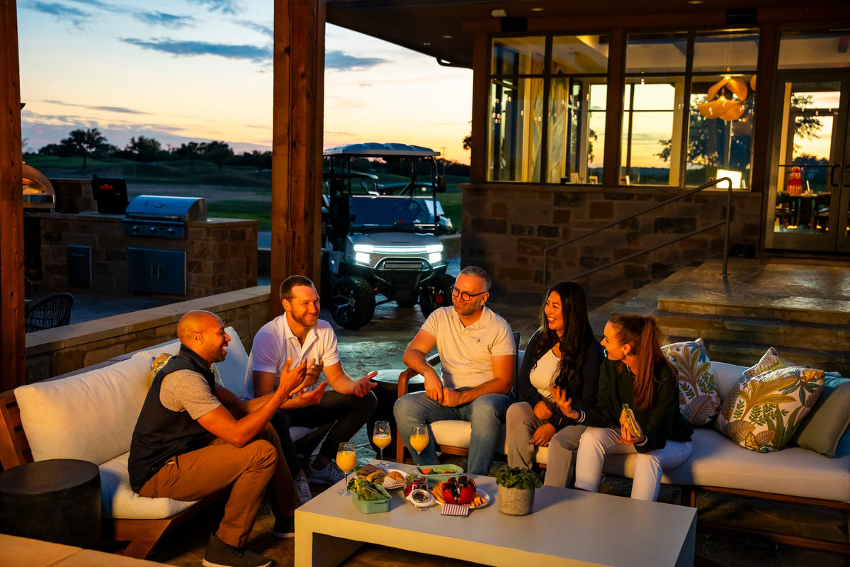Friends enjoying an evening on a patio with a Denago Nomad XL in the background
