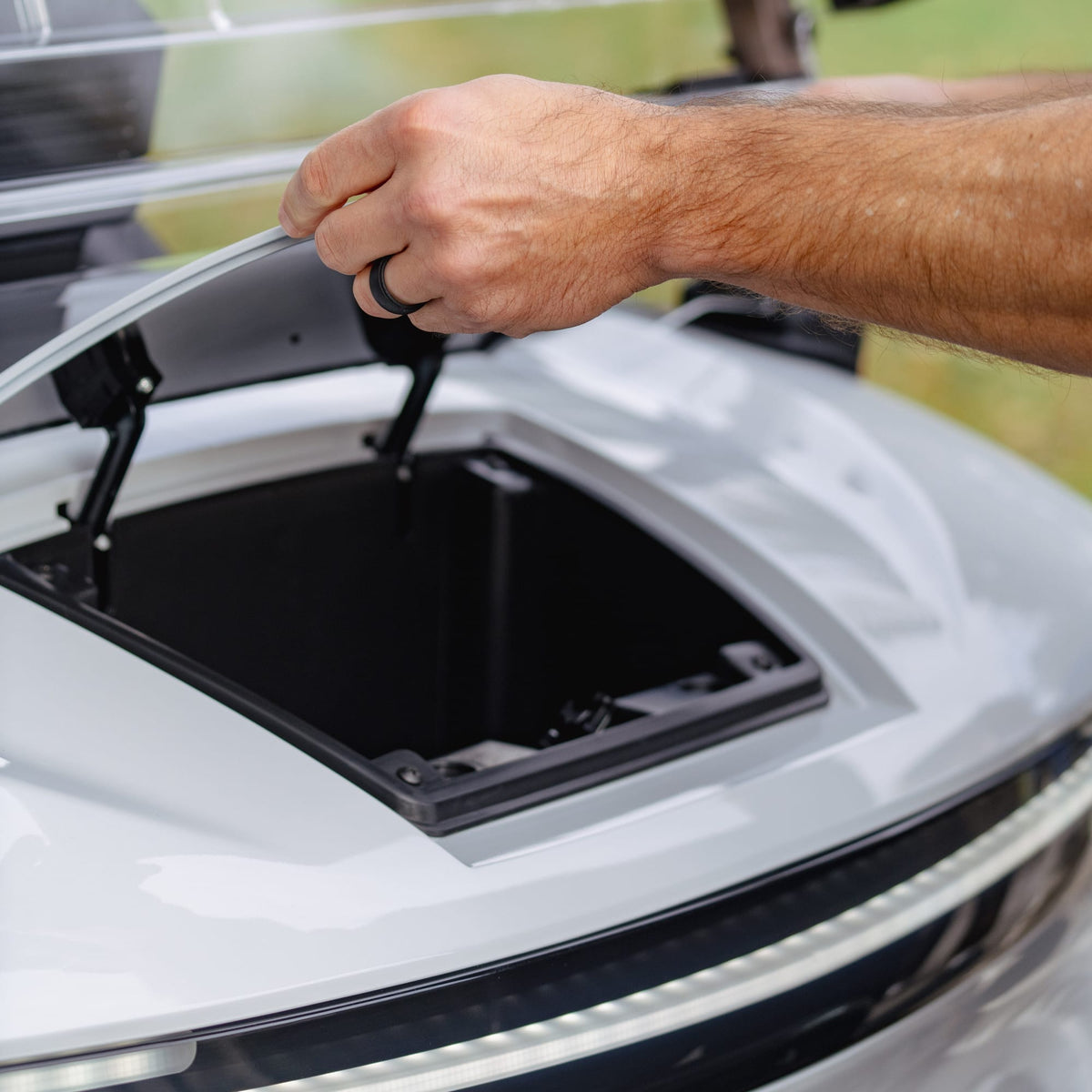 Opening the front storage compartment on a silver Denago Rover XXL
