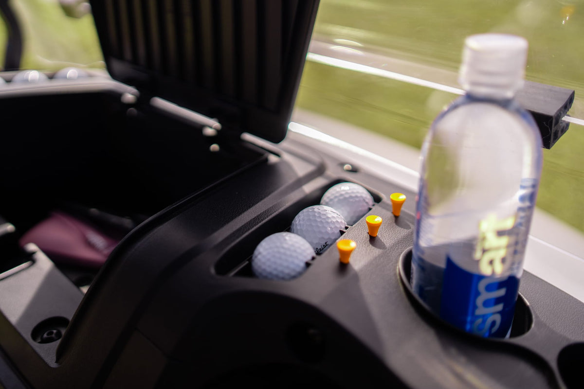 Golf balls, tees and a water bottle held beside the Scout 2 front storage compartment
