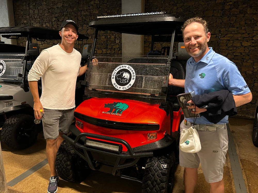 Two visitors beside a red golf cart inside the Fourbuy showroom