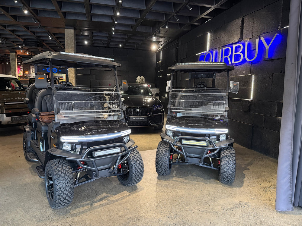 Golf carts inside the showroom beneath the illuminated Fourbuy sign